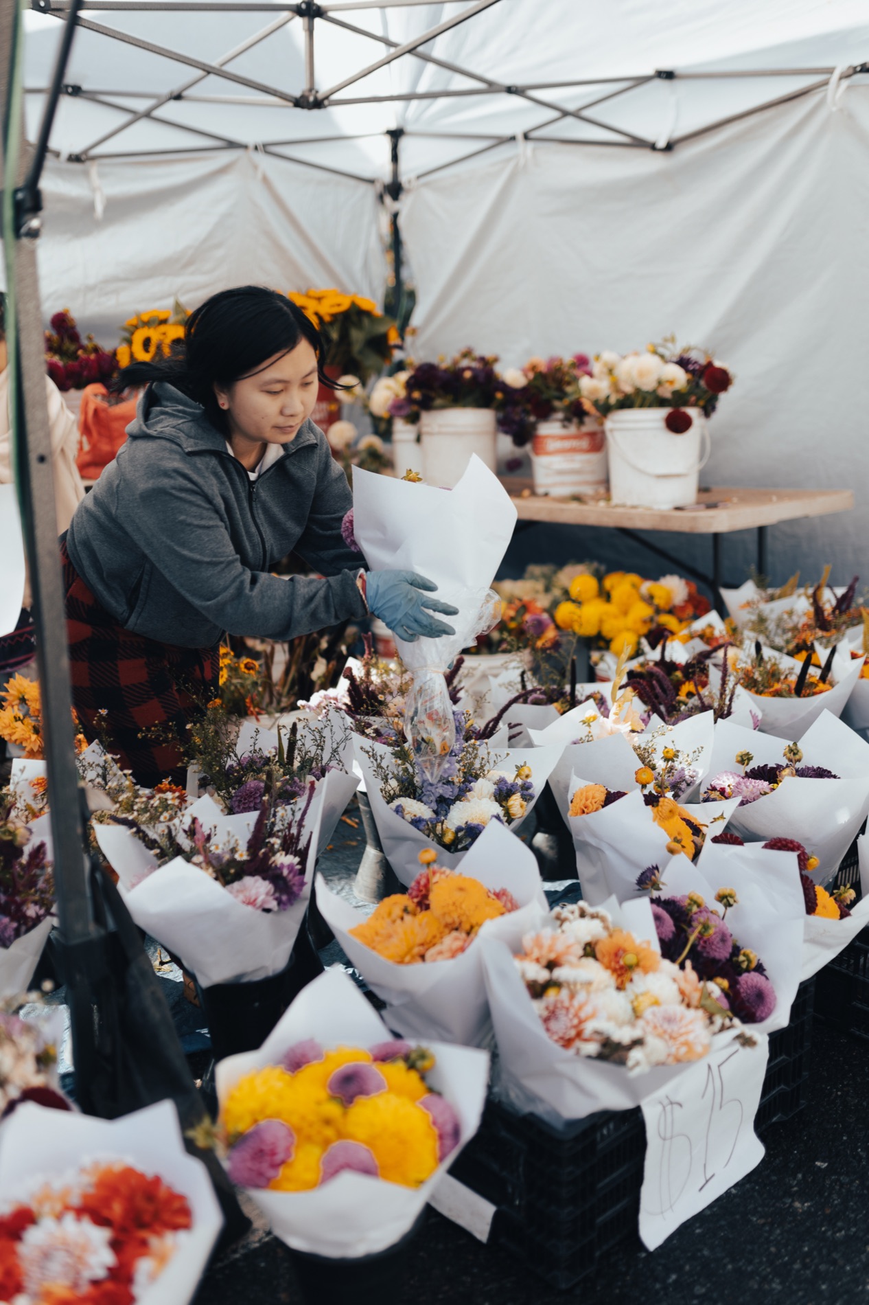 A flower vendor arranging a bouquet at Edmonds Farmers Market