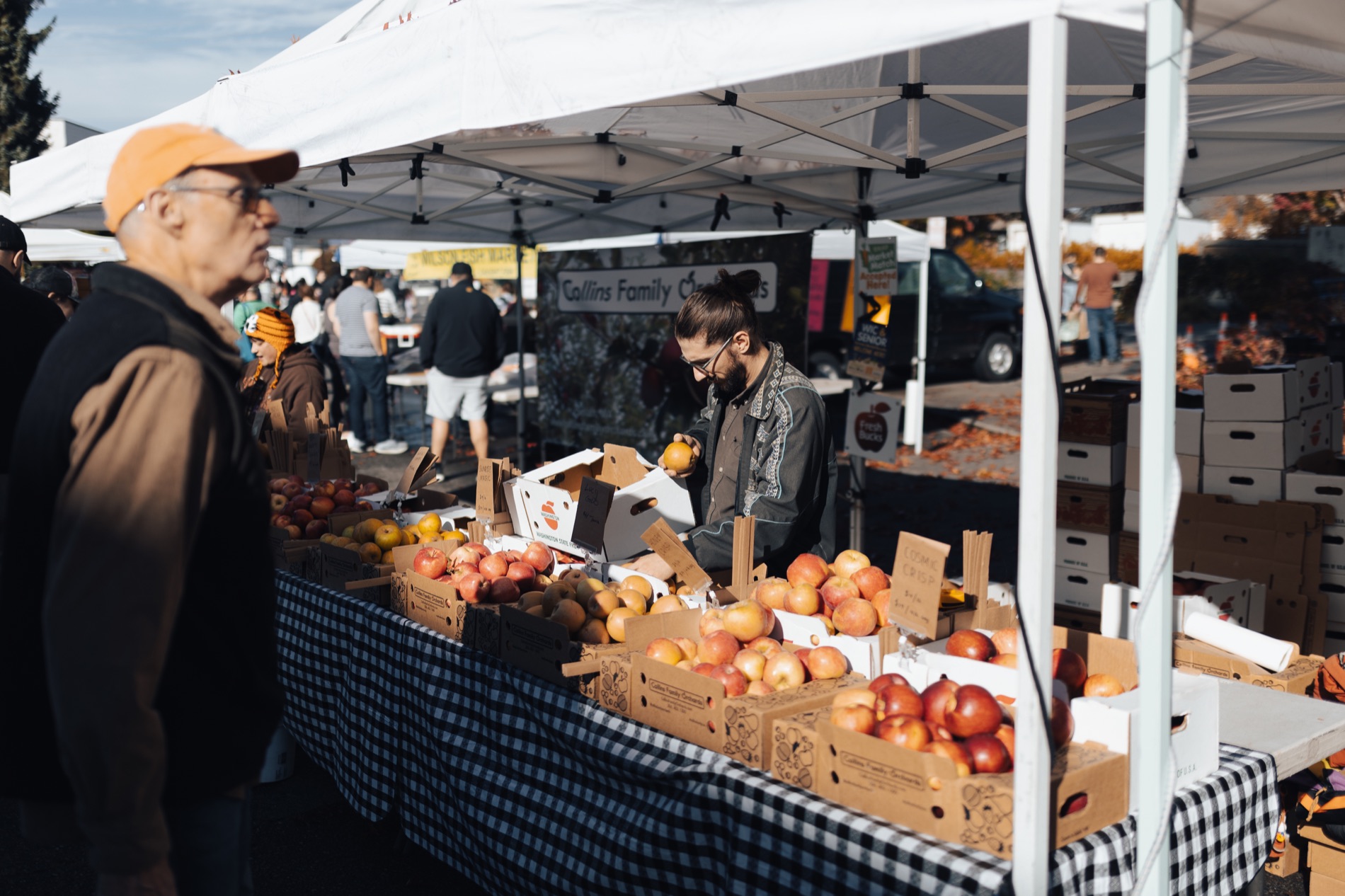 People shopping at an Edmonds Farmers Market produce stand